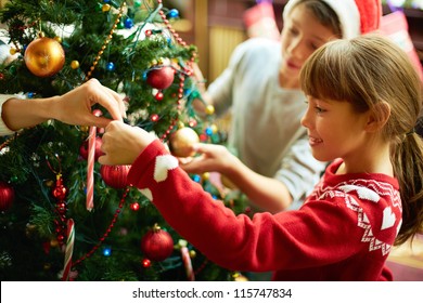 Portrait Of Happy Girl Decorating Christmas Tree