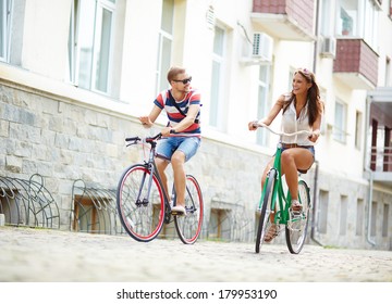 Portrait of happy girl and guy cycling at leisure - Powered by Shutterstock