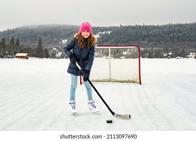 A Portrait Of Happy Girl Hockey Player On A Lake