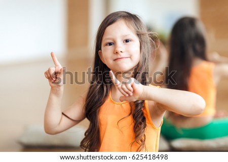 Portrait of happy girl in sports clothes, orange top, close-up, fitness for children