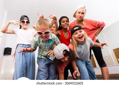 Portrait Of Happy Girls And Boys Hip Hop Dancers And Woman Instructor Posing During Group Dance Workout