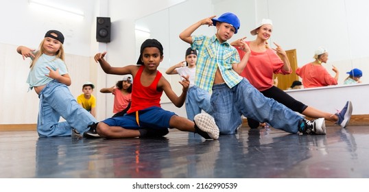 Portrait Of Happy Girls And Boys Hip Hop Dancers And Woman Instructor Posing During Group Dance Workout