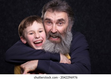 Portrait Of A Happy Grandfather With A Beard And Grandson On A Black Background.