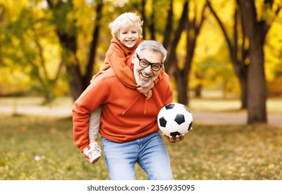 Portrait of happy grandfather and grandson with ball while playing football   in autumn park
 - Powered by Shutterstock