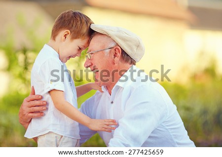 portrait of happy grandfather and grandson bow their heads