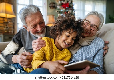 Portrait of happy grandparents with child playing together at home - Shutterstock ID 2117314628