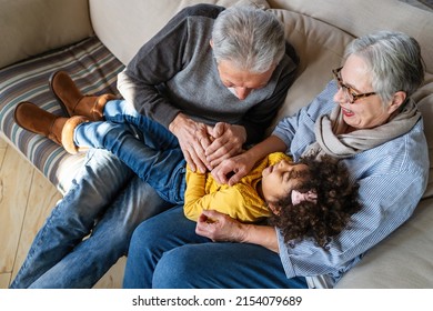 Portrait of happy grandparents with child playing together at home - Powered by Shutterstock