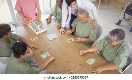 Portrait Of Happy Group Of Old Elderly Asian Patient Or Pensioner People With A Nurse And Doctor Playing Games In Nursing Home. Senior Lifestyle Activity Recreation. Retirement Community. Health Care