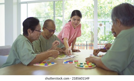 Portrait Of Happy Group Of Old Elderly Asian Patient Or Pensioner People With A Nurse Playing Games In Nursing Home. Senior Lifestyle Activity Recreation. Retirement Community. Health Care