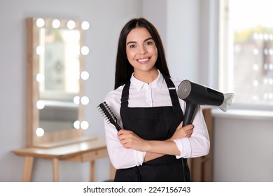 Portrait of happy hairdresser with professional tools in beauty salon - Powered by Shutterstock