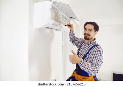 Portrait Of Happy Handsome Moustached AC Maintenance Service Worker Holding Screwdriver, Looking At Camera, Smiling And Showing Thumbs Up After Repairing Wall Air Conditioner Unit At Home Or In Office