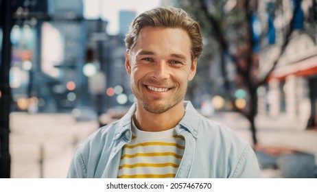 Portrait of a Happy Handsome Young Man in Casual Clothes Posing on the Street. Successful Male Model in Big City Living the Urban Lifestyle. Background with Office Buildings and Billboards. - Powered by Shutterstock