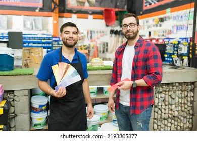 Portrait Of A Happy Hardware Store Worker And Young Man Or Customer Showing The Color Paint Swatches While Shopping