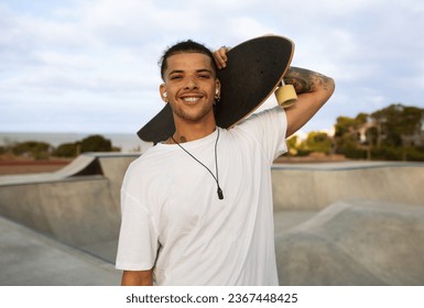 Portrait of happy hipster tattooed european man in white t-shirt posing with skateboard, walking in skate park and smiling at camera, free space - Powered by Shutterstock