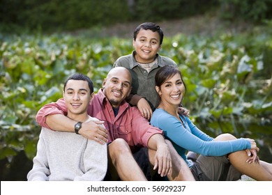 Portrait Of Happy Hispanic Family With Two Boys Outdoors