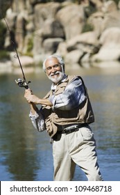 Portrait Of Happy Hispanic Senior Man Fishing On A Sunny Day