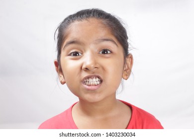 Portrait Of A Happy Indian Little Girl In Red T-shirt Raising Her Hands Up, Isolated Over White, Happy Girl In Red Sport T-shirt. Angle