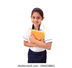 Portrait of a happy Indian school girl wearing uniform smiling and holding note books.