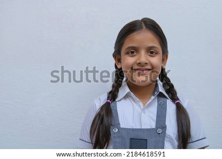 Portrait of a happy Indian school girl with ponytails