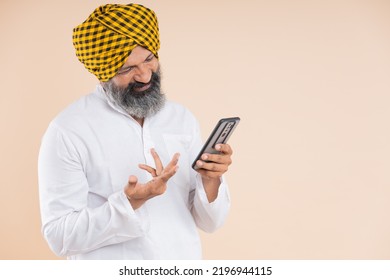 Portrait Of Happy  Indian Sikh Farmer Using Mobile 