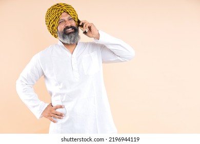 Portrait Of Happy  Indian Sikh Farmer Talking On Phone 