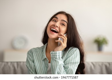 Portrait Of Happy Indian Woman Speaking On Mobile Phone, Having Conversation With Her Friend At Home. Cheerful Millennial Lady Discussing News With Her Family On Cellphone