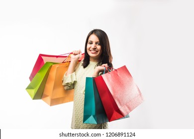 Portrait of a happy Indian woman or young girl carrying shopping bags, isolated over white background
