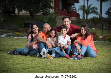 Portrait Of Happy Indian/Asian Family While Sitting On Lawn, Outdoor
