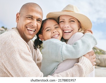 Portrait of happy interracial family on vacation in summer. Smiling and laughing parents bonding with their daughter outside and having fun on the beach. Cute little girl embracing her mom in a hug - Powered by Shutterstock