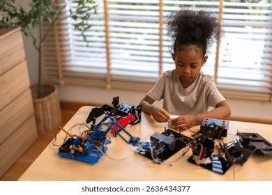 Portrait happy kid african girl having fun hobby leisure lifestyle activity learn and skill brain training play with toy STEM education science control robot technology learning at home