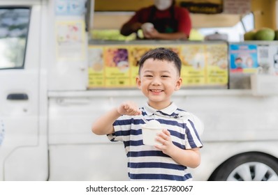 portrait happy kid Thai boy eating coconut ice cream milk with a smile on food ice cream truck background. funny kid Korean boy child eats icecream coconut in the summer in Thailand.food truck people. - Powered by Shutterstock