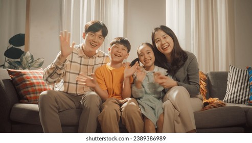 Portrait of a Happy Korean Family in the Living Room at Home, Smiling and Waving at the Camera. Screen Replacement for Video Call With Family and Friends. Heartwarming Shot of Friendly People - Powered by Shutterstock