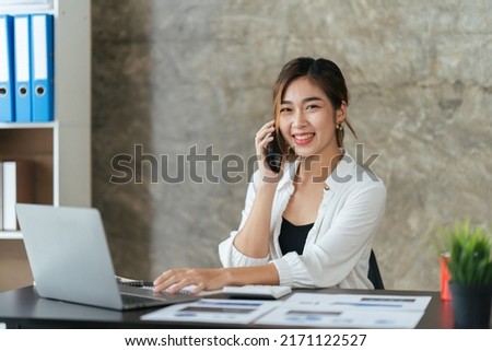 Portrait of happy lady typing in mobile while locating at desk in office, Young business woman on the phone at office.