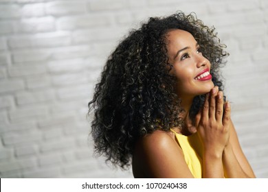 Portrait Of Happy Latina Woman Smiling And Saying Prayer. Black Girl Looking Up While Praying.