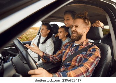 Portrait of happy laughing smiling family of four with children riding in modern car traveling by automobile together enjoying vacation or road trip on weekend. Family travel concept. - Powered by Shutterstock