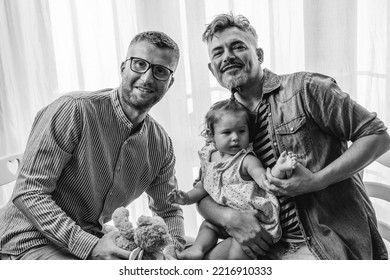 Portrait Of Happy LGBTQ Family At Home - Gay Couple And Their Daughter - Diversity Concept And LGBTQ Family Relationship - Black And White