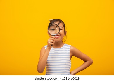 Portrait Of Happy Little Asian Child With Magnifying Glass.