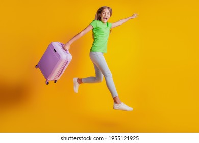 Portrait of happy little child girl jumping carry travel bag wear casual clothes on yellow background - Shutterstock ID 1955121925