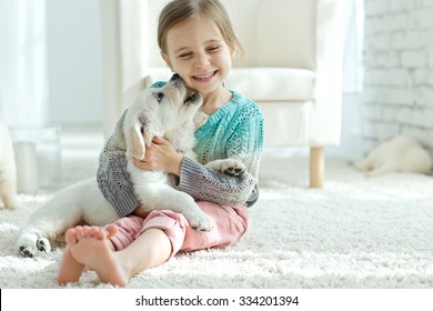 Portrait of happy little girl at home with labrador puppy - Powered by Shutterstock