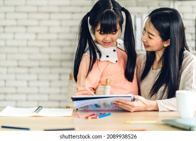 Portrait happy love asian family mother teach little daughter asian girl learn   study table Mom   asian young girl writing and book   pencil making lessons in homeschool at home Education
