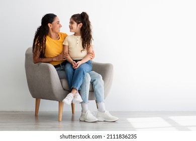 Portrait of Happy Loving Family Of Two Mother And Daughter Relaxing In Chair At Home, Young Mom And Cute Female Child Looking At Each Other And Smiling, Enjoying Spending Time Together, Copy Space - Powered by Shutterstock