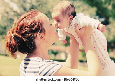 Portrait of happy loving mother and her baby outdoors - Shutterstock ID 186864950