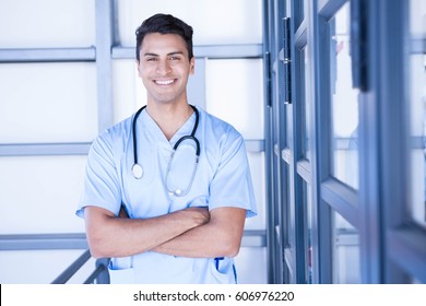 Portrait of happy male doctor standing with arms crossed in hospital - Powered by Shutterstock