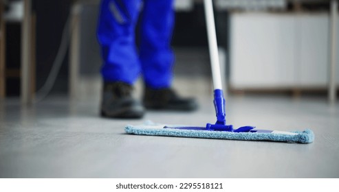 Portrait Of Happy Male Janitor Cleaning Floor At Office