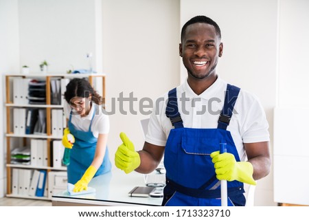 Portrait Of A Happy Male Janitor With Cleaning Equipment In Office Foto d'archivio © 
