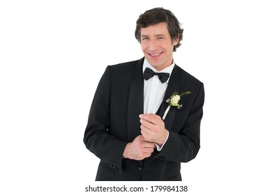 Portrait Of Happy Man Adjusting Cuff Links Before Wedding Over White Background