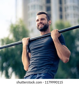 Portrait of happy man, doing pulling up exercise at horizontal bar, during workout training, outdoors. Fitness, sport, exercising and workout in city concept.  - Powered by Shutterstock