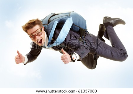 Portrait of happy man flying with parachute and showing thumbs up