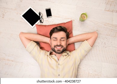Portrait of happy man lying on floor and dreaming about smth - Shutterstock ID 404238727