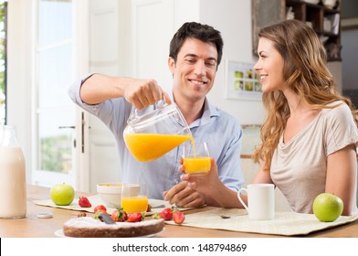 Portrait Of Happy Man Pouring Juice In Glass For Young Woman - Powered by Shutterstock